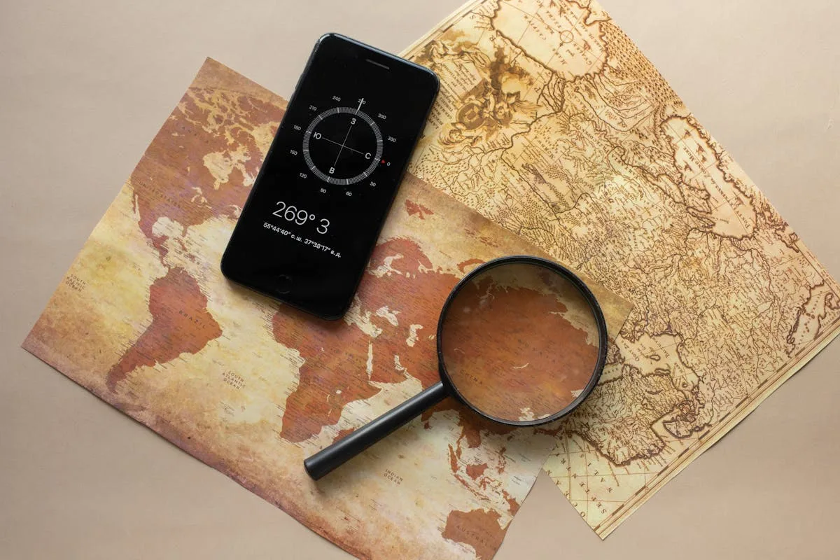 Magnifying glass and smartphone on map — forensic investigation using photo EXIF metadata