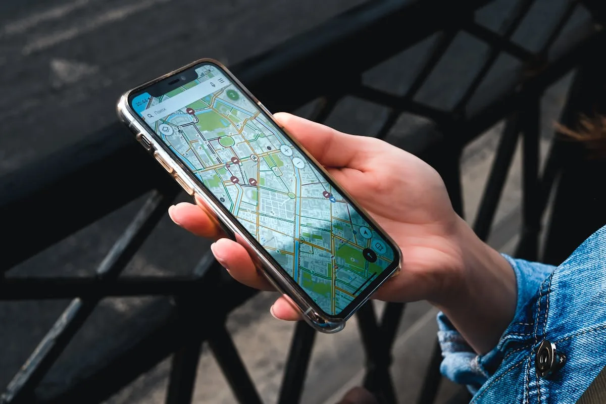 Hand holding iPhone with map app showing GPS location data